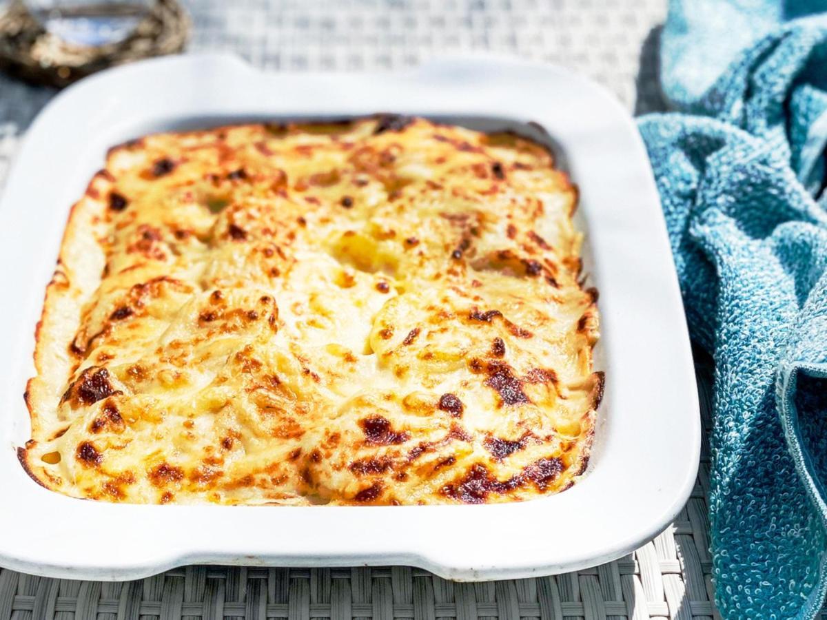فندق كوبي ميريكين بارك أورينتال كوبه المظهر الخارجي الصورة The photo shows a baked dish in a white rectangular casserole dish. The dish appears to have a golden-brown, crispy top, indicating that it has been baked to perfection. It looks creamy and cheesy, suggesting it could be a type of gratin or casserole
